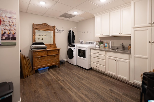 clothes washing area with dark wood-style floors, a sink, cabinet space, and washer and dryer