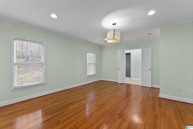 spare room featuring light wood-type flooring and crown molding