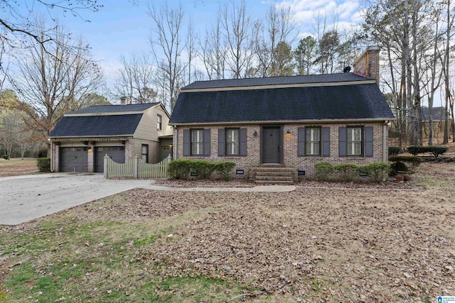 view of front of property with a garage and an outbuilding