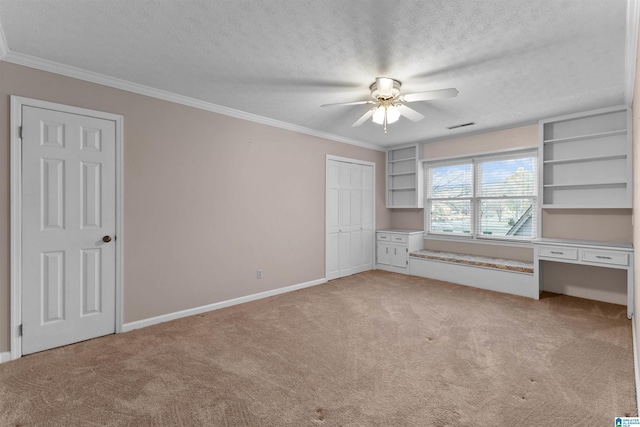 unfurnished bedroom featuring ornamental molding, light carpet, and a textured ceiling