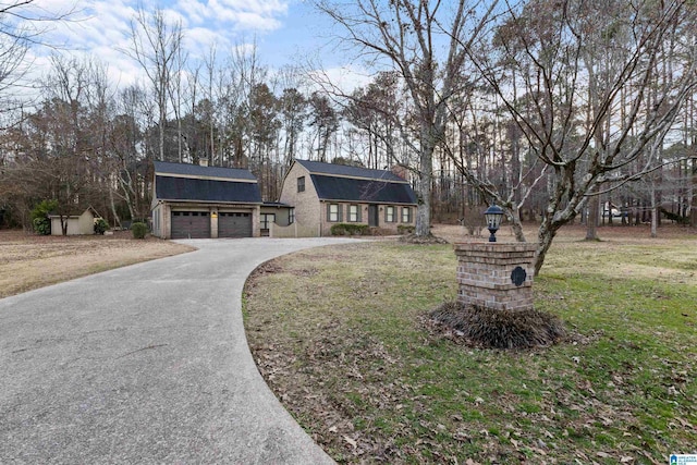 view of front of home with a shed, a front lawn, and a garage