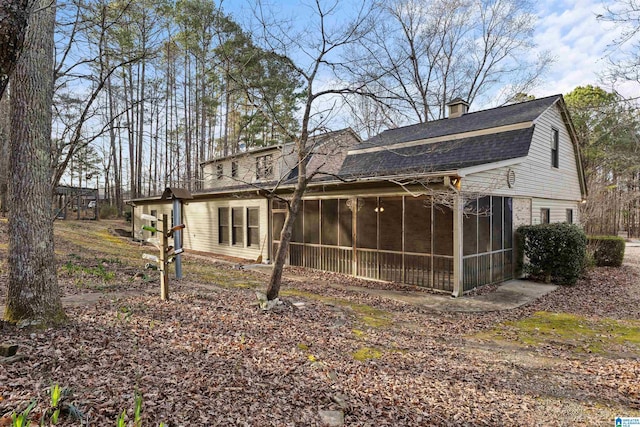 rear view of property featuring a sunroom