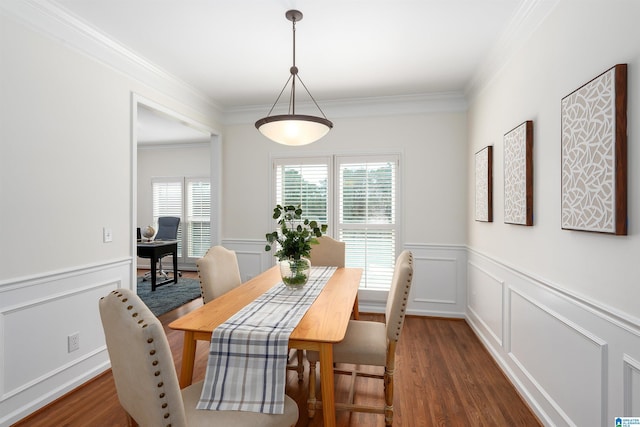 dining area featuring plenty of natural light, crown molding, dark wood-style flooring, and wainscoting