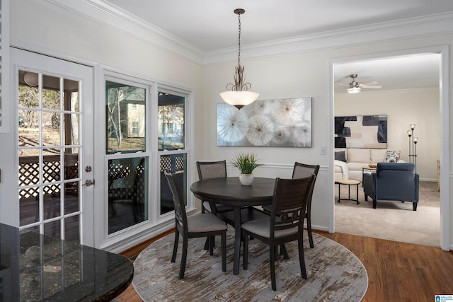 dining area with baseboards, dark wood finished floors, and crown molding