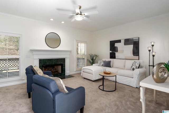 carpeted living room featuring a ceiling fan, a tile fireplace, crown molding, and recessed lighting