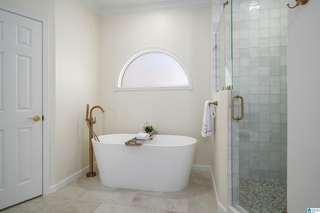 bathroom with a freestanding tub, crown molding, a shower stall, and baseboards