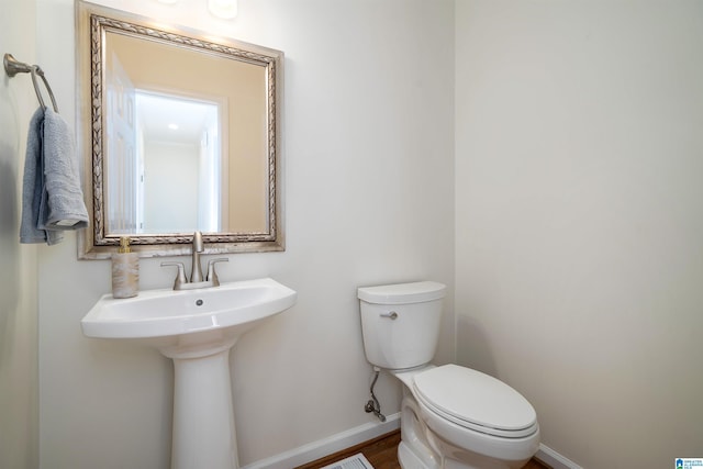 half bathroom with toilet and baseboards