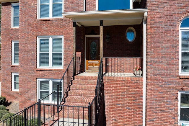 view of exterior entry featuring brick siding