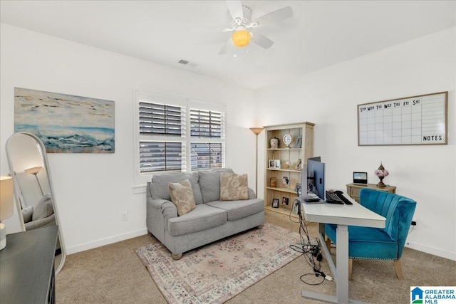 home office featuring baseboards, ceiling fan, visible vents, and light colored carpet