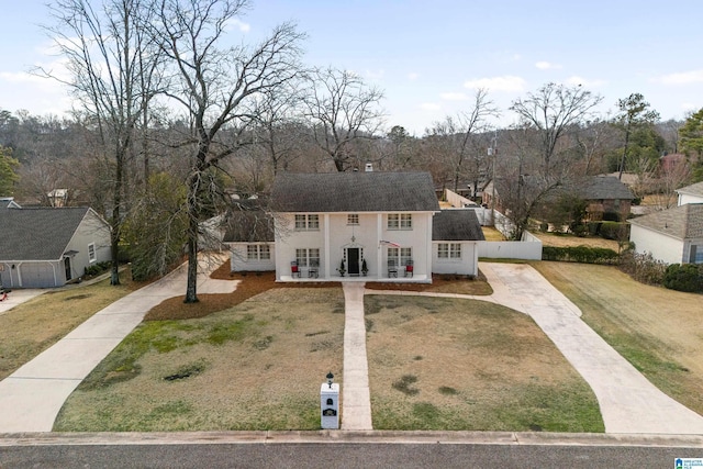 colonial inspired home featuring driveway and a front yard