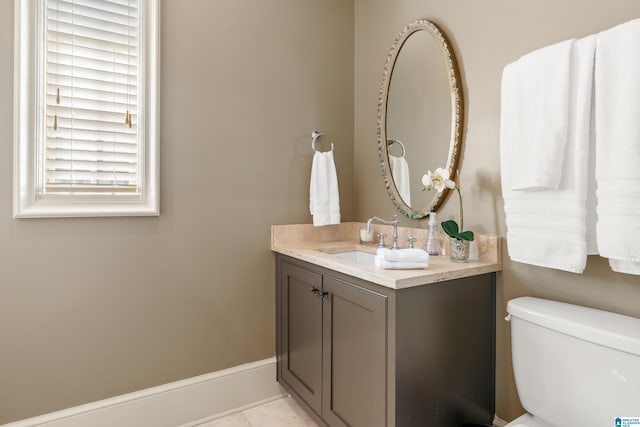 bathroom featuring baseboards, toilet, vanity, and tile patterned floors