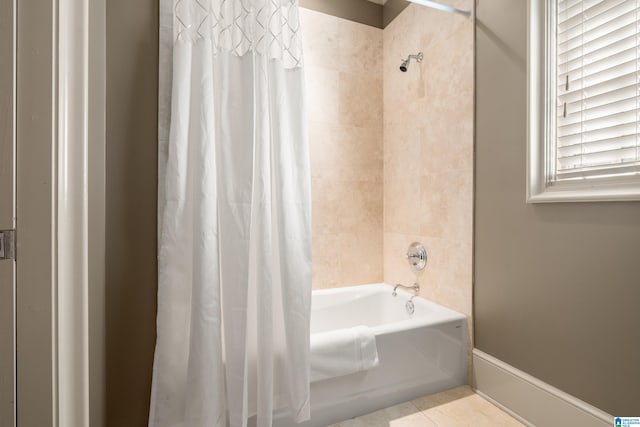 bathroom featuring baseboards, tile patterned flooring, and shower / tub combo with curtain