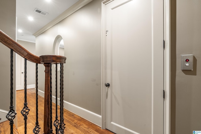 stairway with recessed lighting, wood finished floors, visible vents, baseboards, and crown molding