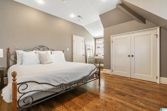 bedroom featuring baseboards, visible vents, vaulted ceiling, and dark wood finished floors