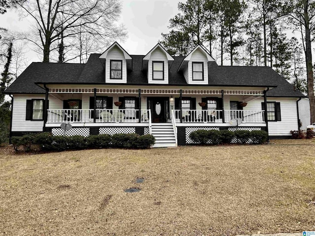 view of front of property featuring a porch, roof with shingles, and a front yard