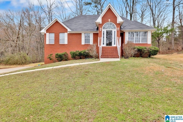 view of front of house with brick siding and a front lawn