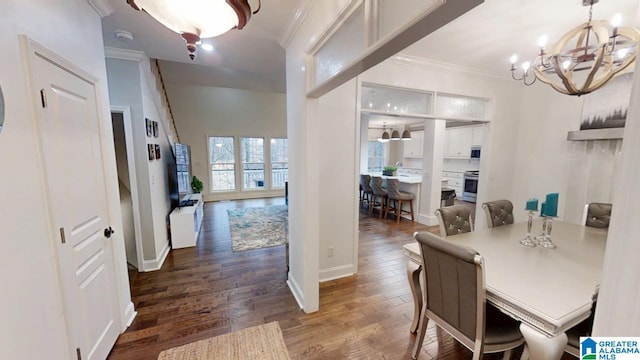 dining room with baseboards, dark wood-style flooring, an inviting chandelier, and ornamental molding