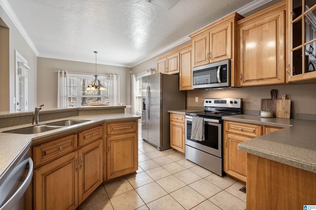 kitchen featuring a sink, light tile patterned floors, hanging light fixtures, ornamental molding, and stainless steel appliances