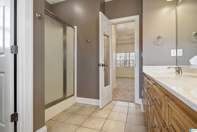 bathroom featuring vanity, tile patterned flooring, baseboards, and a stall shower