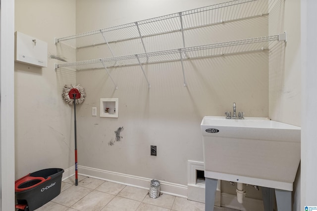 washroom with washer hookup, hookup for an electric dryer, laundry area, baseboards, and tile patterned floors