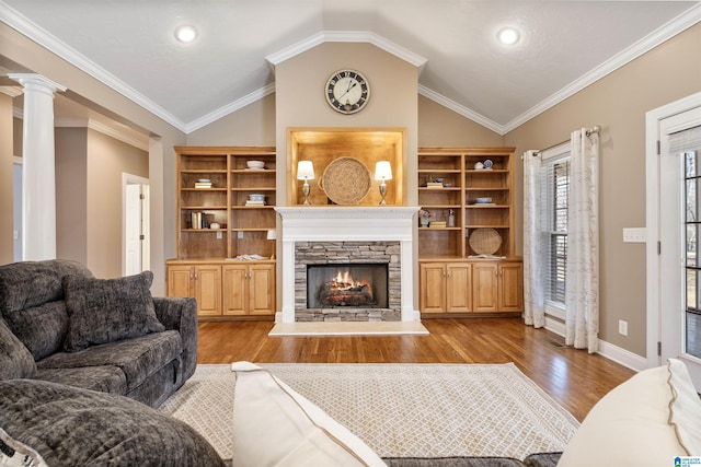 living area with ornate columns, ornamental molding, lofted ceiling, light wood-style floors, and a fireplace