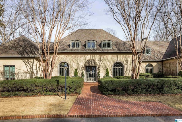 french country home with stucco siding