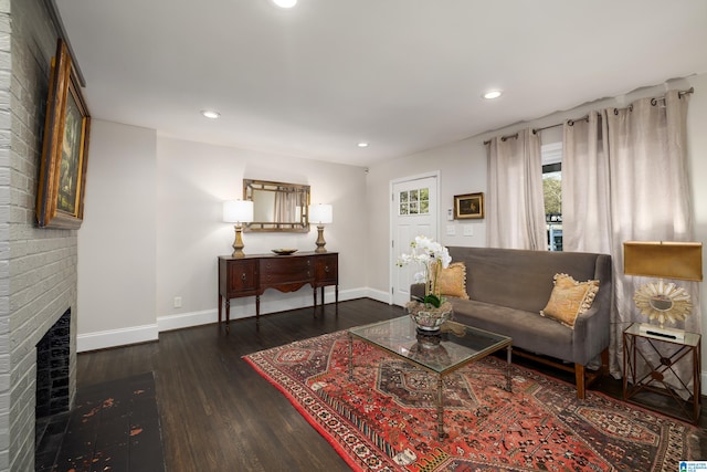 living area with recessed lighting, a fireplace, dark wood finished floors, and baseboards