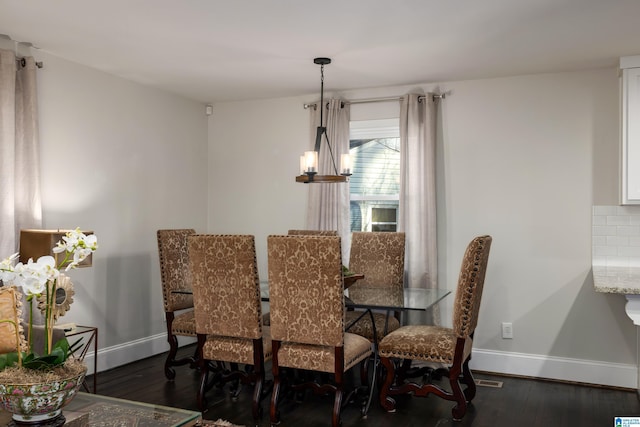 dining area with baseboards, dark wood finished floors, and a notable chandelier