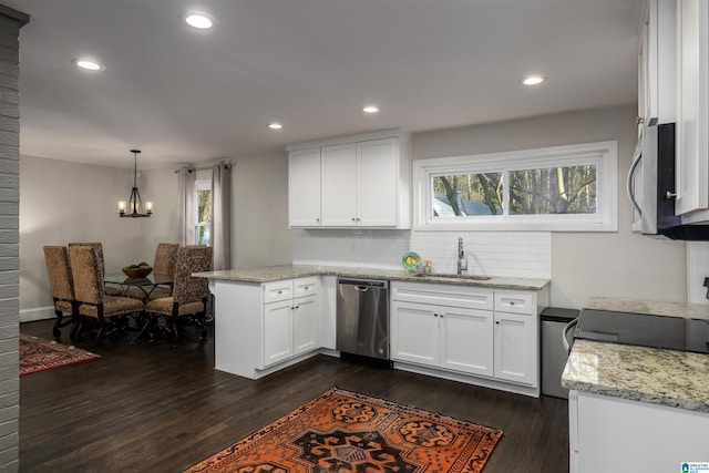 kitchen featuring stainless steel appliances, pendant lighting, white cabinets, and a sink