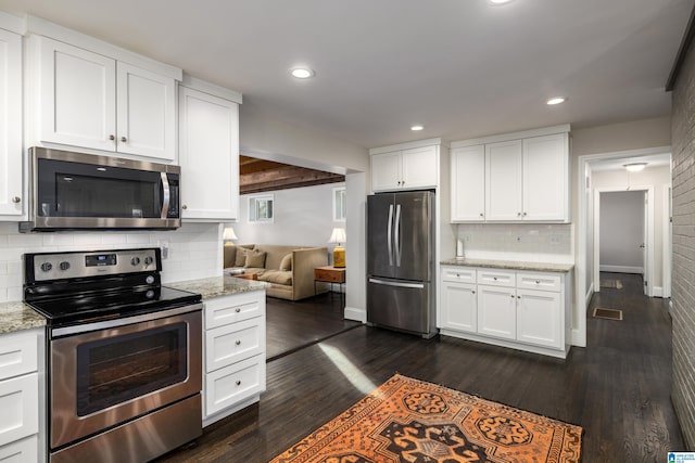 kitchen featuring dark wood-style floors, stainless steel appliances, light stone countertops, and white cabinets