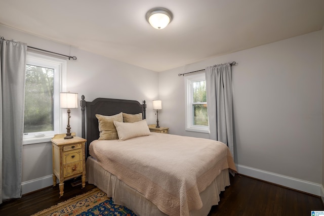 bedroom featuring dark wood-style flooring and baseboards