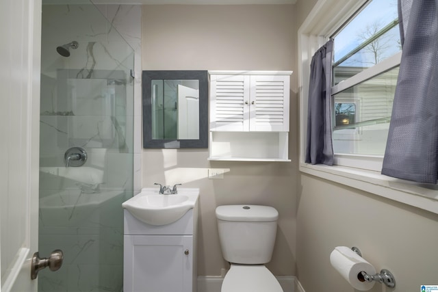 full bathroom featuring vanity, a marble finish shower, and toilet