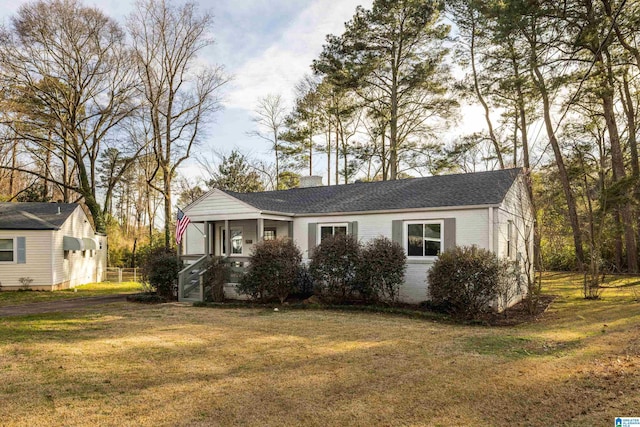 view of front of property with a front yard, brick siding, and roof with shingles