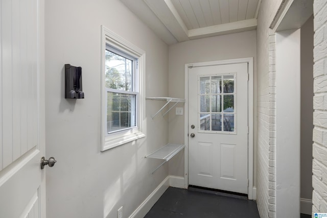 doorway with concrete floors and baseboards