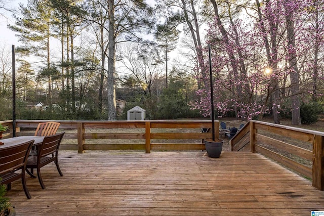 wooden terrace featuring a storage unit and an outdoor structure