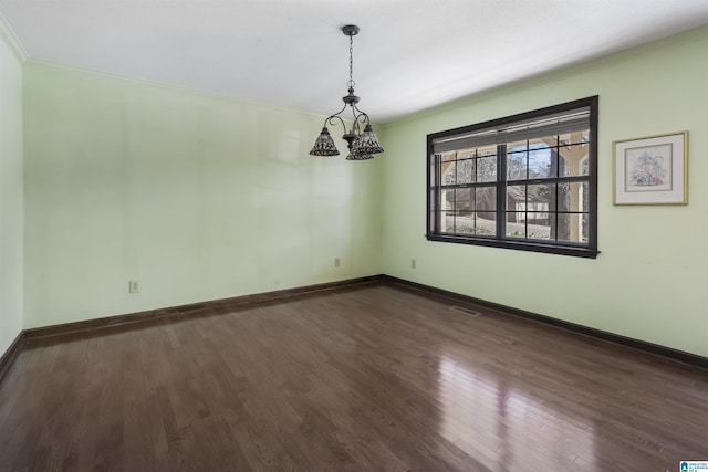 spare room with dark wood-style floors, baseboards, and ornamental molding