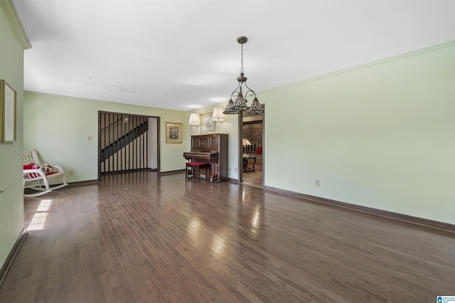 unfurnished living room featuring dark wood finished floors, stairway, and baseboards