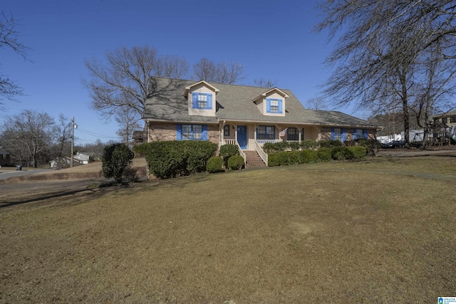 cape cod-style house with a front yard and brick siding