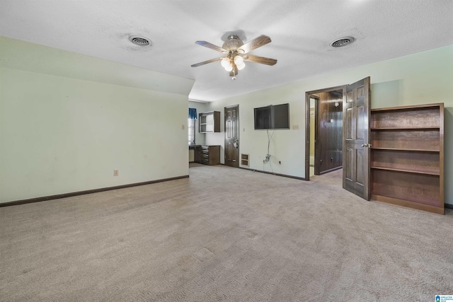 unfurnished bedroom with baseboards, visible vents, a textured ceiling, and light colored carpet