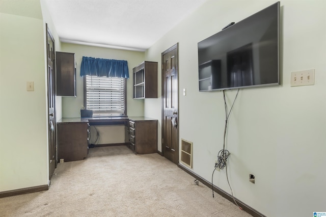 interior space featuring light colored carpet, visible vents, and baseboards