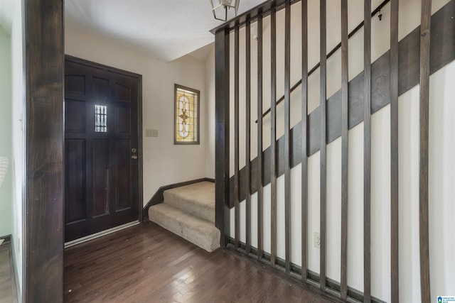 entryway featuring dark wood-type flooring, stairway, and baseboards