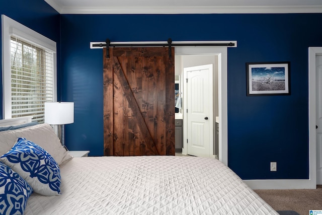 bedroom with carpet floors, a barn door, and crown molding