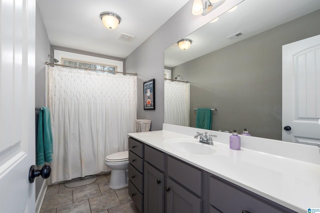 bathroom featuring toilet, a shower with shower curtain, vanity, and visible vents