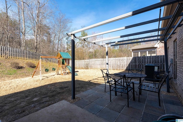 view of patio / terrace with outdoor dining area, a playground, a fenced backyard, central air condition unit, and a pergola