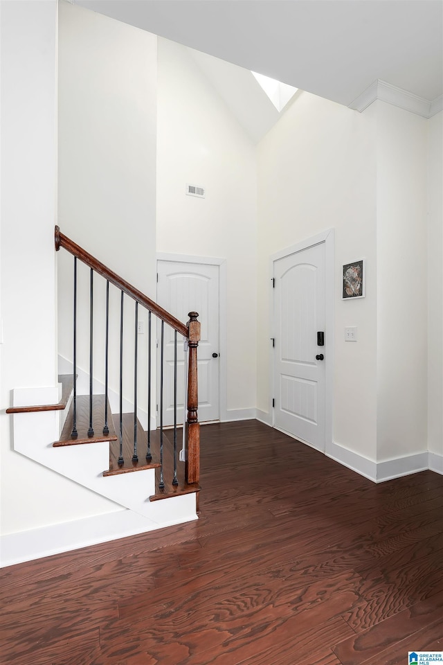 foyer with visible vents, dark wood finished floors, stairway, and baseboards