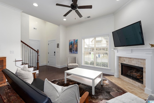 living area with stairway, baseboards, visible vents, and crown molding