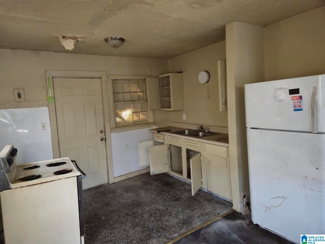 kitchen featuring light countertops, a sink, a textured ceiling, unfinished concrete floors, and white appliances