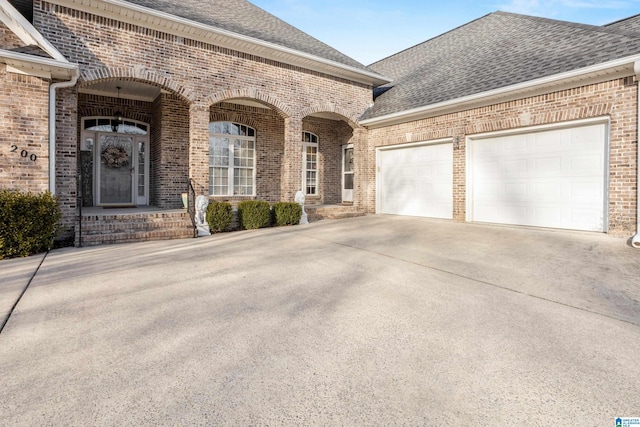 french provincial home with concrete driveway, brick siding, roof with shingles, and an attached garage