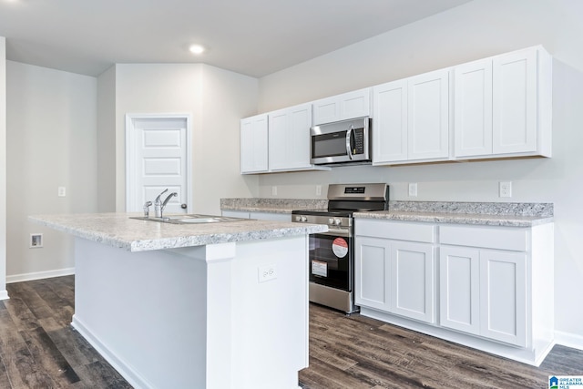 kitchen with white cabinets, an island with sink, stainless steel appliances, light countertops, and a sink