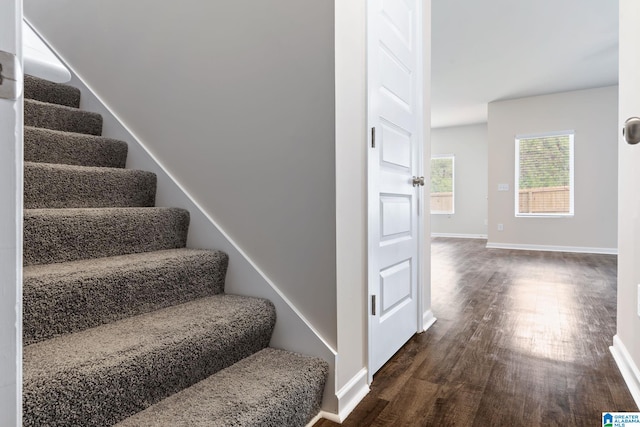 staircase featuring baseboards and wood finished floors